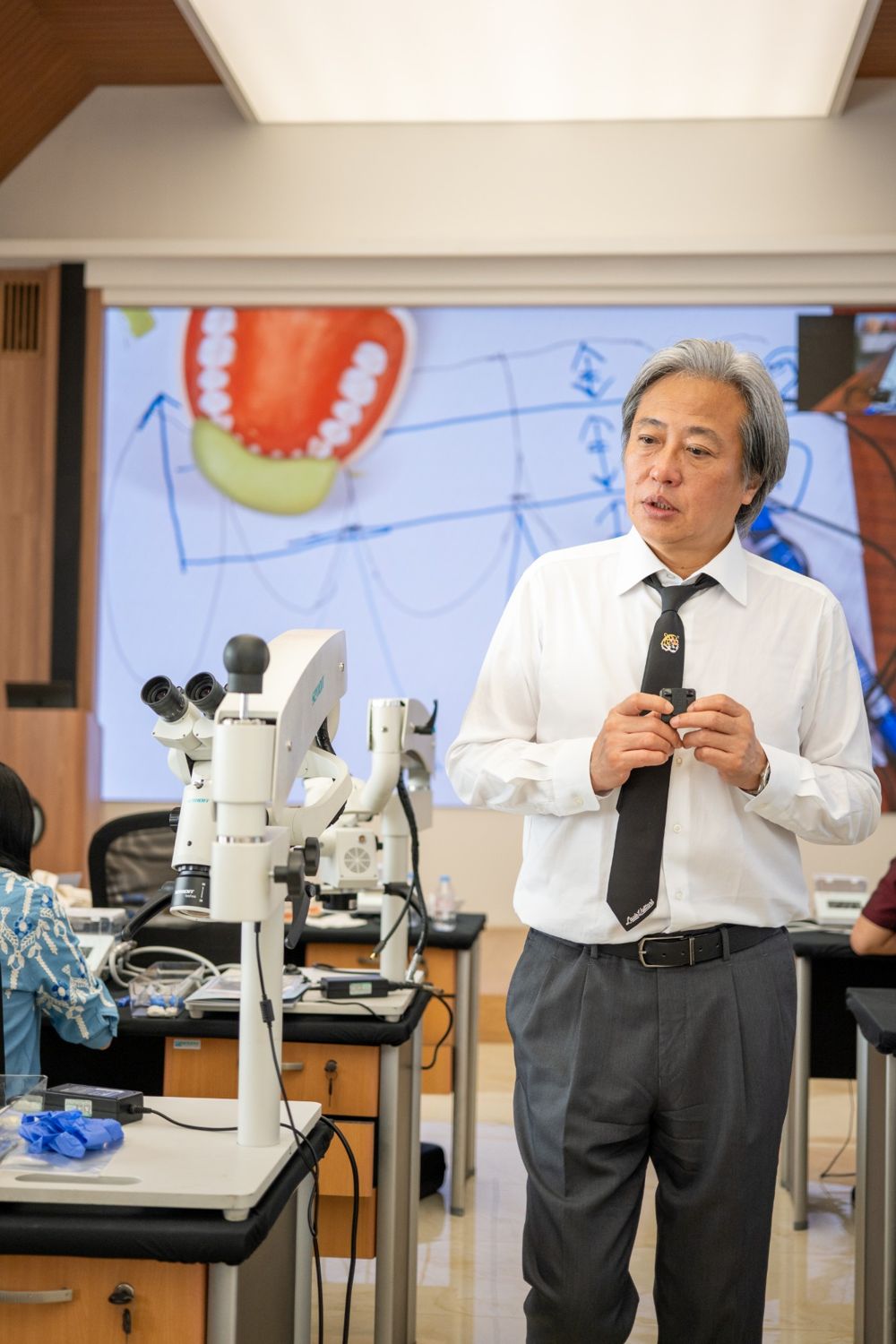 Dr. Okawa menjelaskan desain preparasi di ruang kelas bermikroskop